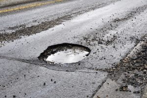 Slow down to avoid potholes on the road